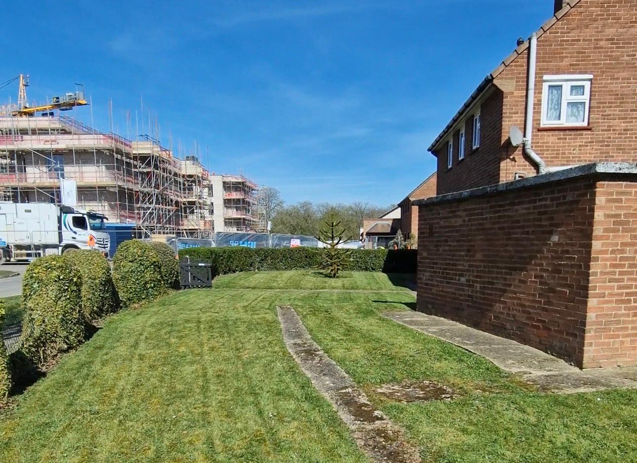 Front lawn with topiary hedges and clean mowing stripes by ELawnCare gardener in Cambridge