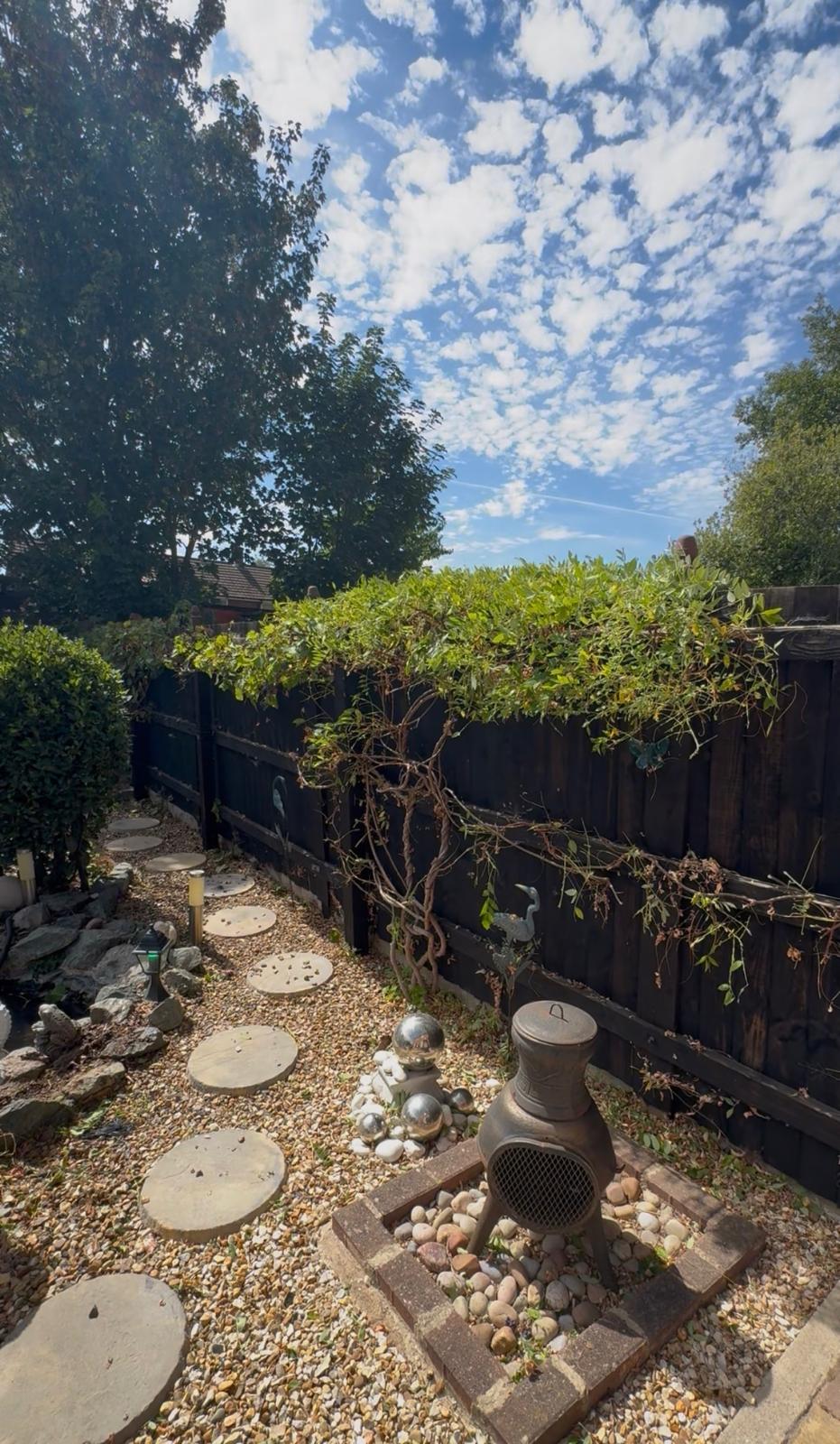 Gravel garden with circular stepping stones and decorative silver gazing balls in Cambridge