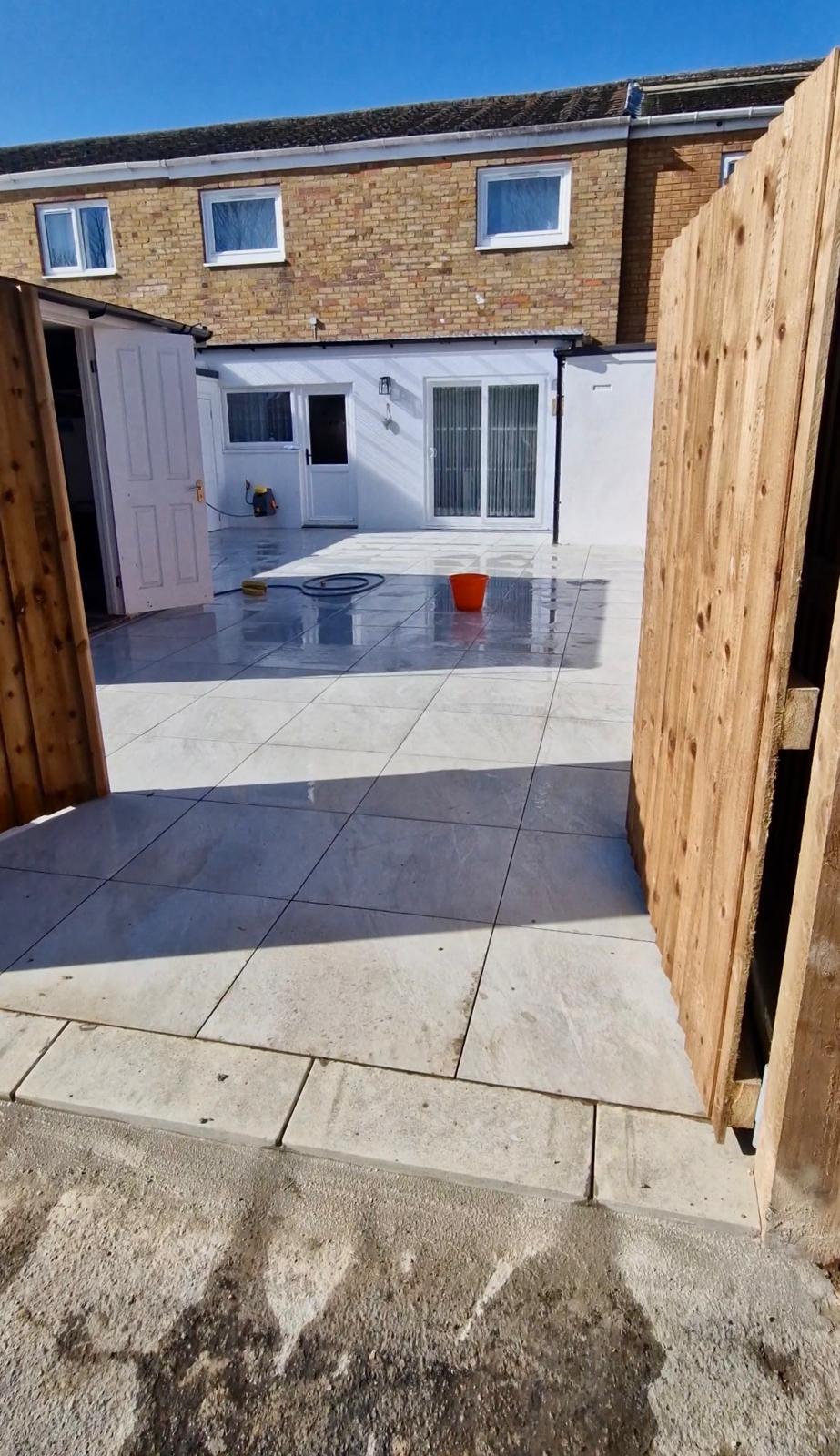 New porcelain patio tiles with timber fencing installed by ELawnCare patio tiling service in Cambridge