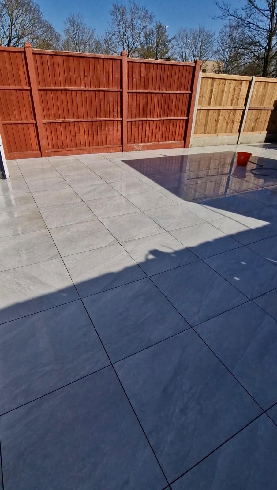 Completed porcelain patio with new lap panel fencing by ELawnCare landscaping in Cambridge